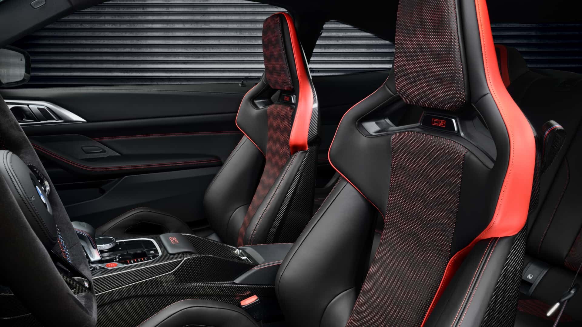 BMW M4 CS interior with carbon-fiber bucket seats, red accents, and a performance-focused cockpit