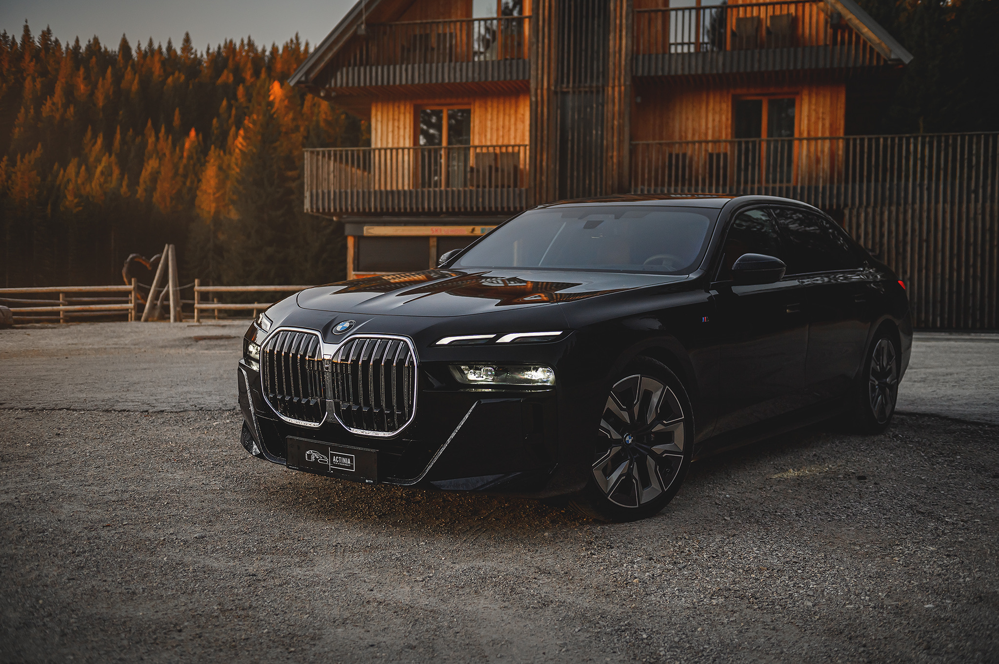 BMW 740d luxury sedan front three-quarter view, showcasing elegant design, iconic kidney grille, and premium executive styling in an alpine setting