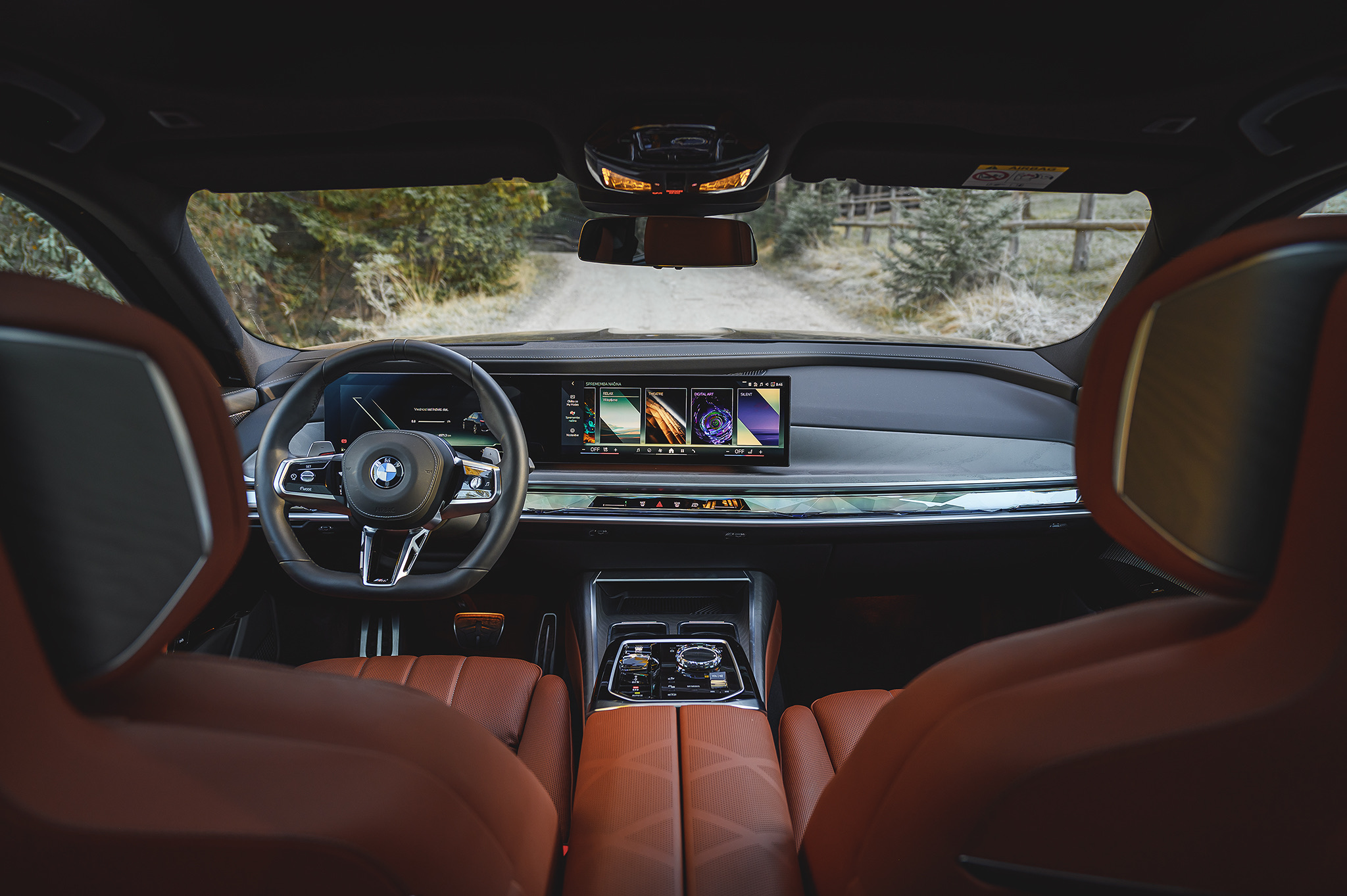 BMW 740d interior showcasing luxury rear seating, curved digital display, premium materials, and advanced infotainment system